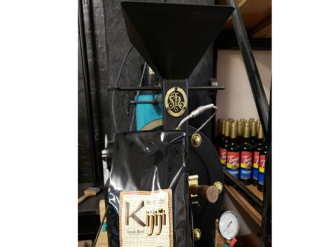 Bag of Kijiji Sumatra Blend Coffee in front of a coffee roaster
